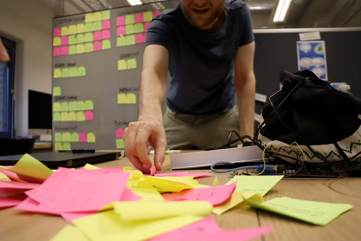 a person standing over a table with many sticky notes