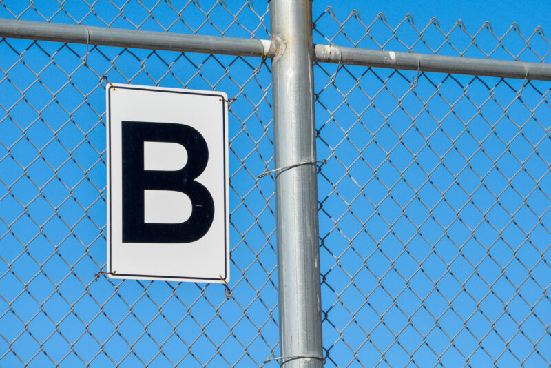 a letter b sign on a chainlink fence