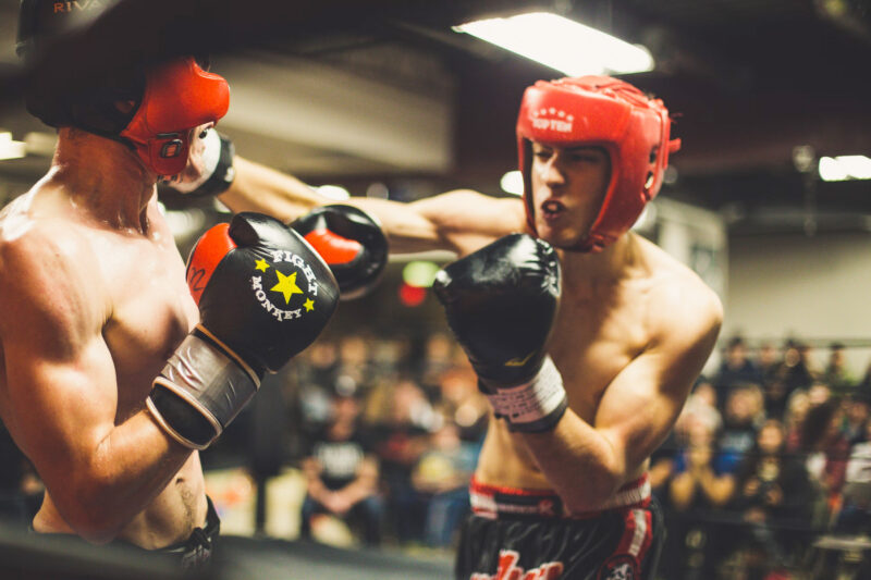 boxers in a ring. One boxer is punching the other